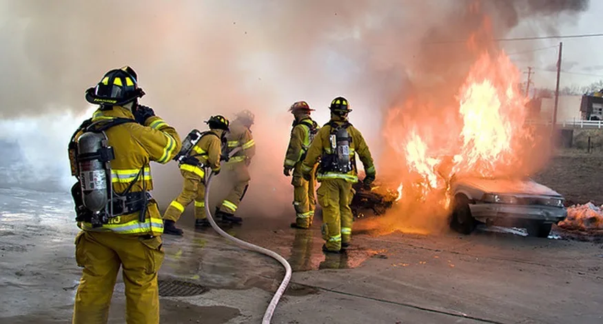 Many fluids are flowing in this scene. Water from the hose and smoke from the fire are visible flows. Less visible are the flow of air and the flow of fluids on the ground and within the people fighting the fire. Explore all types of flow, such as visible, implied, turbulent, laminar, and so on, present in this scene.